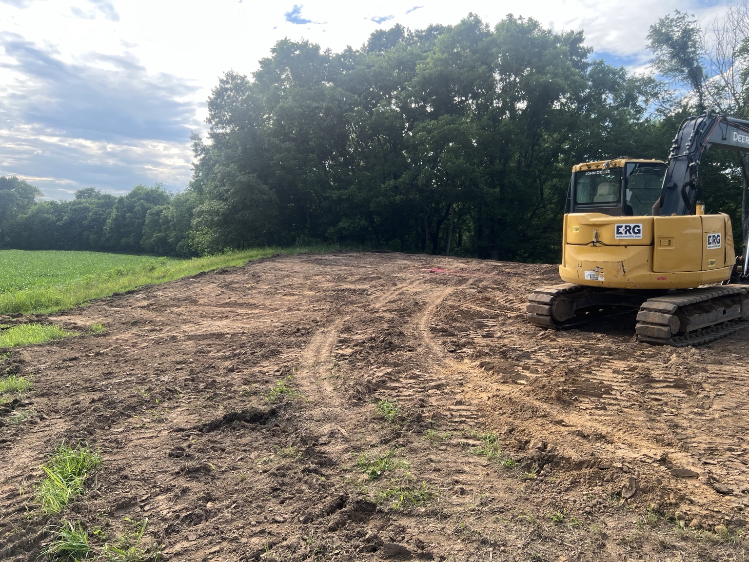 Excavator and roll-off container at a cleared work site
